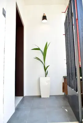 a plant in a white planter in a hallway at The North - Floor apartment in Kato Halandri in Athens