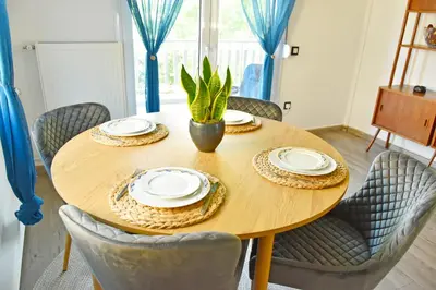 a wooden table with plates and a potted plant on it at The North - Floor apartment in Kato Halandri in Athens