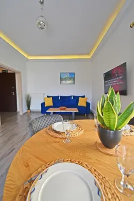 a dining room with a table and a blue couch at The North - Floor apartment in Kato Halandri in Athens