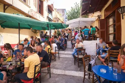 a group of people sitting at an outdoor restaurant at White Rose Athens Residence in Athens