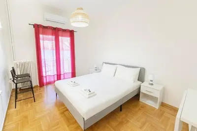 a bedroom with a white bed and a red window at Athenian Cosy Getaway 2 in Athens