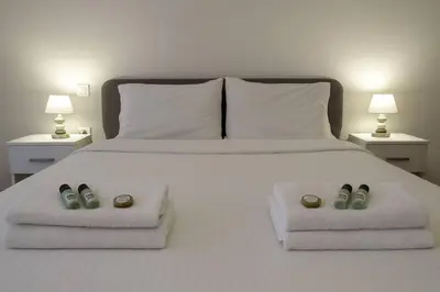 a large white bed with two pillows and two lights at Athenian Cosy Getaway 2 in Athens