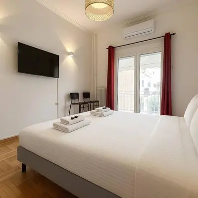 a bedroom with a large white bed and a window at Athenian Cosy Getaway 2 in Athens