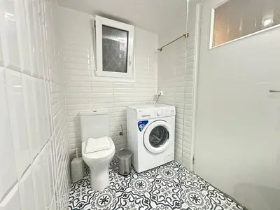 a bathroom with a washing machine and a washer at Athenian Cosy Getaway 2 in Athens