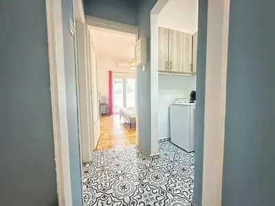 a hallway of a kitchen with a refrigerator and a counter at Athenian Cosy Getaway 2 in Athens