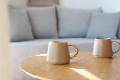 two coffee mugs sitting on top of a wooden table at AeroHill Suites Near Athens Airport By SEM in Artemida