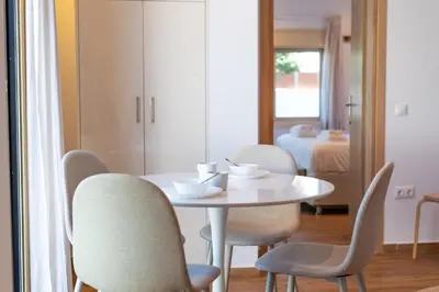 a dining room with a white table and chairs at AeroHill Suites Near Athens Airport By SEM in Artemida