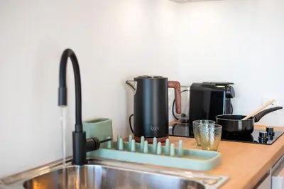 a kitchen counter with a sink and a counter top at AeroHill Suites Near Athens Airport By SEM in Artemida