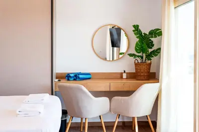 a room with a table and two chairs and a mirror at AeroHill Suites Near Athens Airport By SEM in Artemida