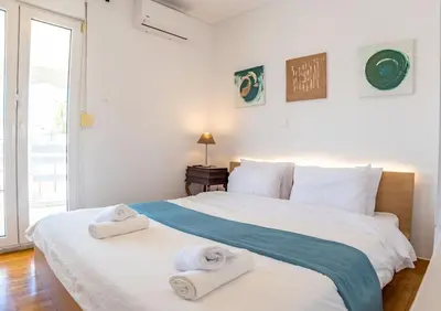 a bedroom with a large white bed with towels on it at Kolonaki Penthouse - Acropolis View - 5min Metro in Athens