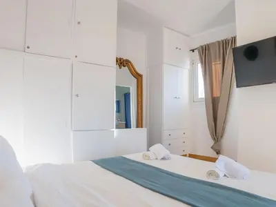 a white bedroom with a bed with towels on it at Kolonaki Penthouse - Acropolis View - 5min Metro in Athens