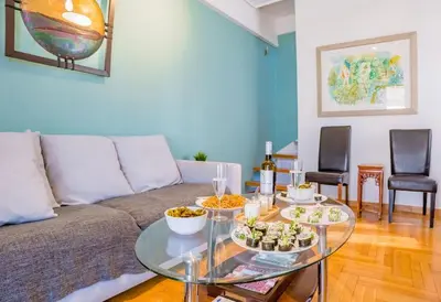 a living room with a couch and a glass table at Kolonaki Penthouse - Acropolis View - 5min Metro in Athens