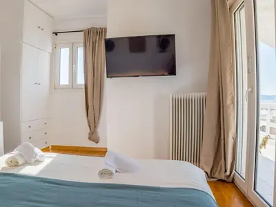 a bedroom with a bed and a tv on the wall at Kolonaki Penthouse - Acropolis View - 5min Metro in Athens