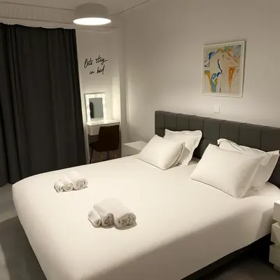 a bedroom with a white bed with towels on it at Alexandra's Apartment in Athens