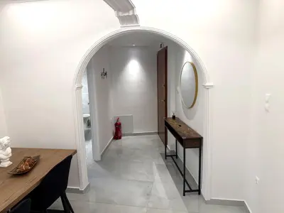 a hallway with an archway with a table and a mirror at Alexandra's Apartment in Athens