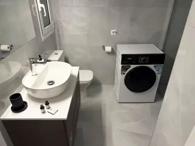 a small bathroom with a washing machine in it at Alexandra's Apartment in Athens
