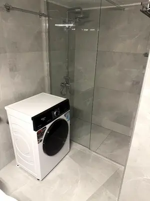 a washing machine in a bathroom with a shower at Alexandra's Apartment in Athens