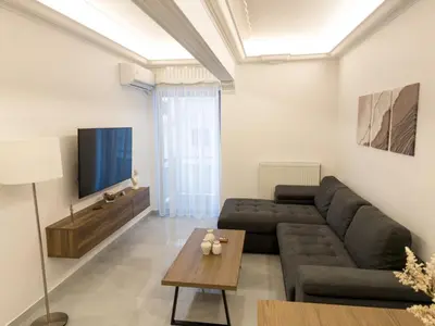 a living room with a couch and a tv at Alexandra's Apartment in Athens