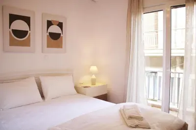 a bedroom with a white bed and a window at ARIS Central Kypseli- Stylish Boho apartments in Athens