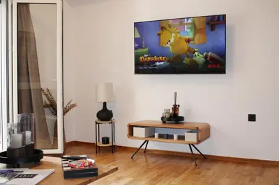 a living room with a table and a video game on the wall at ARIS Central Kypseli- Stylish Boho apartments in Athens