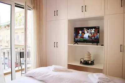 a bedroom with a bed with a tv on a wall at ARIS Central Kypseli- Stylish Boho apartments in Athens