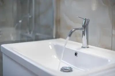 a white sink with a faucet in a bathroom at 2 bedroom apt at Patisia metro station! in Athens