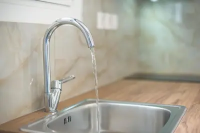 a kitchen sink with water coming from a faucet at 2 bedroom apt at Patisia metro station! in Athens