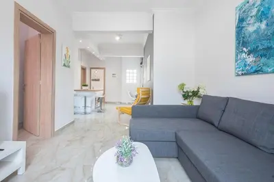 a living room with a couch and a table at 2 bedroom apt at Patisia metro station! in Athens