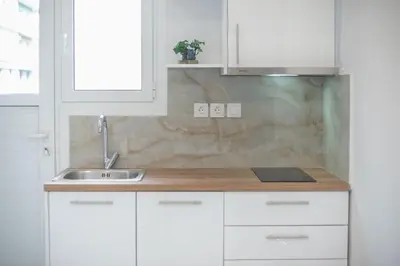 a kitchen with white cabinets and a sink at 2 bedroom apt at Patisia metro station! in Athens