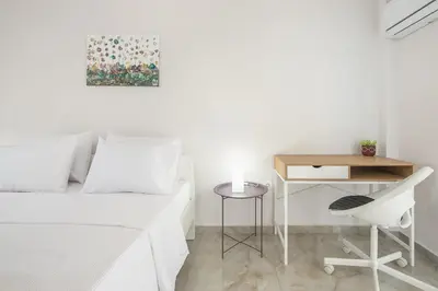 a white bedroom with a desk and a bed and a chair at 2 bedroom apt at Patisia metro station! in Athens