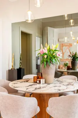a dining room table with a vase of flowers on it at Historic Villa with Hot Tub Beneath the Acropolis in Athens