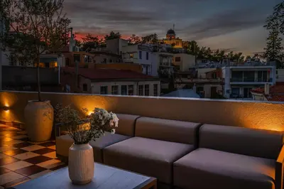 a couch on a balcony with a view of a city at Historic Villa with Hot Tub Beneath the Acropolis in Athens