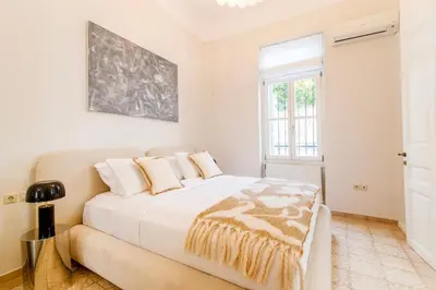 a white bedroom with a bed and a window at Historic Villa with Hot Tub Beneath the Acropolis in Athens