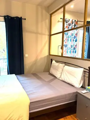 a bedroom with a large white bed with a window at Cosy, Athens core fully renovated apartment in Athens
