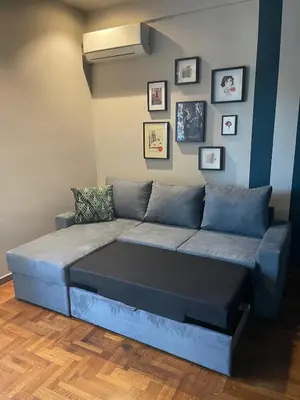 a blue couch in a room with pictures on the wall at Cosy, Athens core fully renovated apartment in Athens