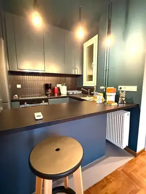 a kitchen with a counter and a table and a stool at Cosy, Athens core fully renovated apartment in Athens