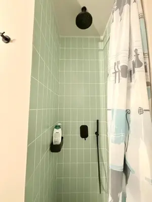 a bathroom with a shower with green tiles at Cosy, Athens core fully renovated apartment in Athens