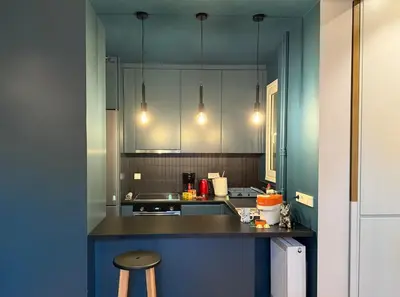 a kitchen with white cabinets and a counter with a stool at Cosy, Athens core fully renovated apartment in Athens