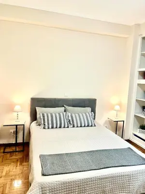 a bedroom with a large bed with two night stands at Bright and central apartment in Athens