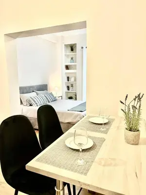 a dining room with a table and chairs and a bed at Bright and central apartment in Athens