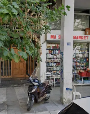 a motor scooter parked in front of a store at Bright and central apartment in Athens