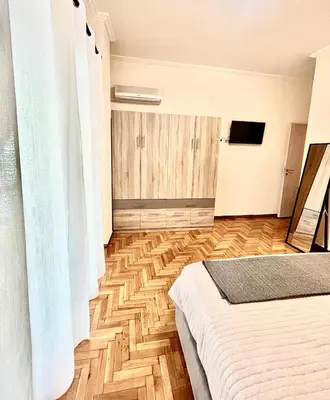 a bedroom with a bed and a wooden floor at Bright and central apartment in Athens
