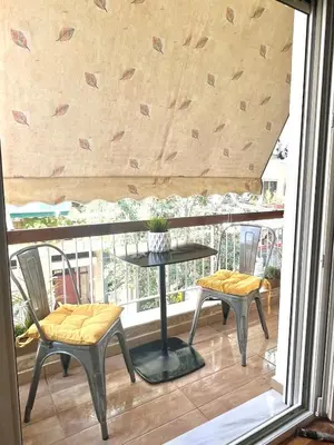 a balcony with two chairs and a table on a balcony at Bright and central apartment in Athens