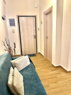 a living room with a green couch and a door at Bright and central apartment in Athens
