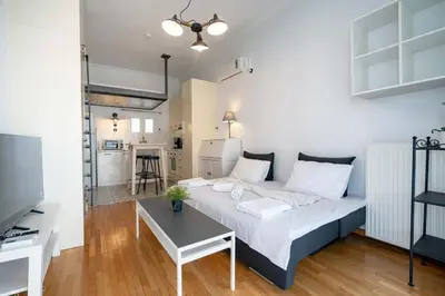 a bedroom with a bed and a table in a room at City Panorama Studio by ΜΡS in Athens