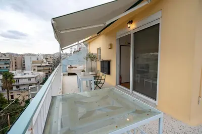 a balcony with a table and a view of a city at City Panorama Studio by ΜΡS in Athens