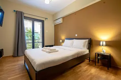 a bedroom with a large bed and a window at Warm 2BR Apt - Central Kypseli by ΜΡS in Athens