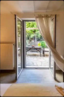 an open door leading to a patio with a table at Detached Garden House in Athens