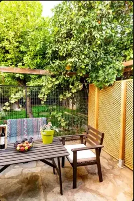a bench and a table with a bowl of fruit at Detached Garden House in Athens