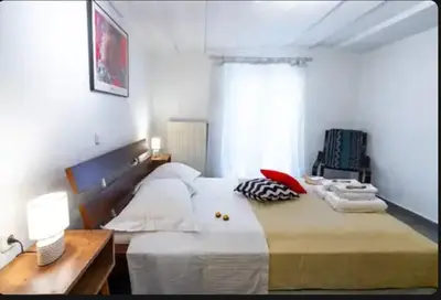 a bedroom with a large bed and a window at Detached Garden House in Athens